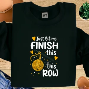 Funny crochet T-shirt featuring “Just Let Me Finish This Row” design. Premium cotton tee for yarn lovers, knitters, and crocheters.