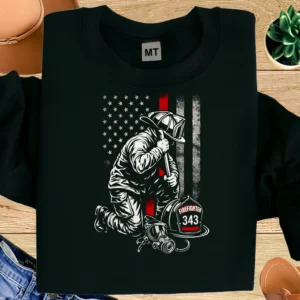 Powerful firefighter memorial T-shirt featuring a kneeling firefighter, Thin Red Line flag, and 343 tribute. Honor fallen heroes with pride.