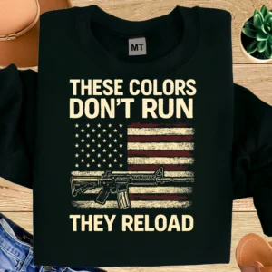These Colors Don’t Run They Reload T-shirt featuring distressed American flag and rifle graphic. Bold patriotic tee for freedom and USA pride lovers.